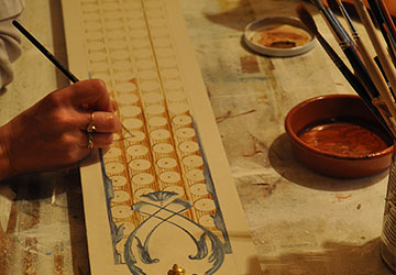 Travail en atelier, exécution des motifs décoratifs peints à main levée